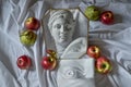 Ancient greek sculpture white plaster marble head among fruits Royalty Free Stock Photo