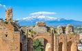 Ancient Greek theatre in Taormina on background of Etna Volcano, Sicily, Italy