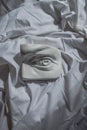 Ancient greek white sculpture marble plaster copy eye of david against background of white drapery fabric with folds