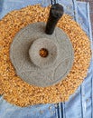 The ancient hand mill or quern stone, grinds the grain into flour. Old handmade grinding stones. The old woman is grinding Royalty Free Stock Photo