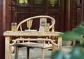 An ancient historic eastern Asian Chinese woodern chair and table desk with two glasses of tea on it in a garden