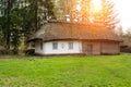 An ancient historical house in the village. A white building with yellow shutters on the windows and a roof made of straw. Royalty Free Stock Photo