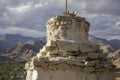 A Ancient holy white Tibetan Buddhist temple on the mountain in the daytime against the backdrop of a mountain valley Royalty Free Stock Photo