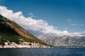 Ancient houses with red roofs and a church bell tower at the foot of the mountains. Perast, Montenegro Royalty Free Stock Photo