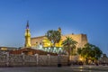 The ancient illuminated Luxor temple at night with dark blue sky and glowing brickwalls