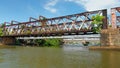 Ancient iron bridge over river. Action. Rusty old bridge over river in tropical area. Iron bridge over river in tropics