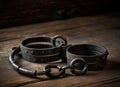 Ancient iron handcuffs on the wooden floor from medieval times. Prisoner Pulse Restrictions.