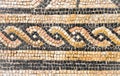 Ancient Italian Roman mosaic floor with circular shapes composed of small colored stone tiles Royalty Free Stock Photo