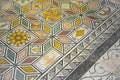 Ancient Italian Roman mosaic floor with geometric shapes composed of small colored stone tiles Royalty Free Stock Photo