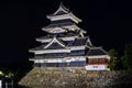 Ancient Japanese Matsumoto Castle at night with a reflection in the moat