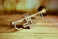 an ancient jazz trumpet on an old wooden table