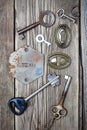 Ancient keys and keyholes on old wooden board