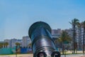 An ancient large cannon stands along tourist promenade of boulevard with slightly raised top against the background of a row of Royalty Free Stock Photo