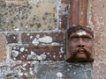 Ancient male head sculpture outside Eggesford Church in Devon, England.