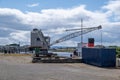 An ancient maritime dock crane with its wheel house and jib visible in the image