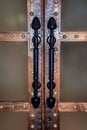 An ancient massive door with a wooden layout and rivets in an oriental style. Long double handles made of ferrous metal, inlaid. F Royalty Free Stock Photo