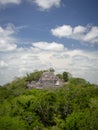 Ancient Mayan stone structure rising out of the jungle canopy at