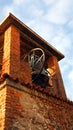 Ancient medieval brick bell tower with bronze bell and blue sky