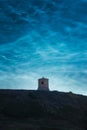 Ancient medieval watchtower on a hill under the beautiful noctilucent clouds in the night sky