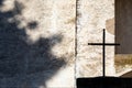 Ancient metal crucifix with church wall background. Royalty Free Stock Photo