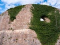 Ancient military fortress stone wall with embrasure view from bottom Royalty Free Stock Photo