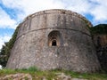 Ancient military fortress stone wall tower with embrasure view from bottom Royalty Free Stock Photo