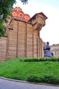 An ancient monument on a hillock of green grass under the building of interesting architecture