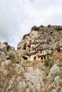 Ancient monumental lycian rock-cut tombs in archaeological site Myra near Demre, Turkey with goats grazing among them Royalty Free Stock Photo