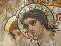 Ancient mosaic on the wall of the temple with the image of angels with golden crowns