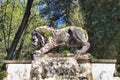 Ancient mossy overgrown lion stone in Villa Borghese