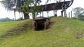 An ancient mound dolmen. Monolithic tomb formed with volcanic rocks into grass at Colombian San Agustin archaeological park.