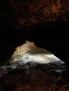 Ancient mountain cave with stalactites, stalagmites, long underground river in white and red stones with petroglyph