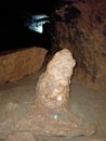 Ancient mountain cave with stalactites, stalagmites, long underground river in white and red stones with petroglyph