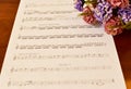 Ancient Musical Manuscript, Abstract Music Sheet and flowers on wooden table Royalty Free Stock Photo