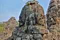 Ancient mysterious temple of Bayon. Huge human faces carved from stone look at all directions.