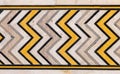 ancient natural Valencia cream travertine marble border with dark gray white and yellow zig zag symmetrical patterns Royalty Free Stock Photo