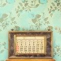 Ancient office table calendar in front of vintage blue wallpaper with floral pattern Royalty Free Stock Photo