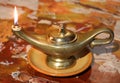 ancient oil lamp with flame on a marble surface Royalty Free Stock Photo