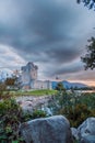 Ancient old Fortress Ross Castle with a lake, green grass and orange clouds. Killarney national park, co Kerry, Ireland