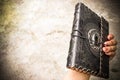 Ancient old leather bound book in the hand os a woman. Royalty Free Stock Photo