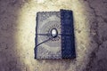 Ancient old leather bound book lying on the ground Royalty Free Stock Photo