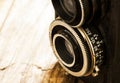 Ancient, old photo camera two lenses on chestnut rustic wooden background