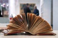 Ancient open book with two people standing in the background