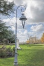 Ancient ornate light next to a pathway in a garden