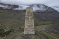 An ancient Ossetian battle tower against the backdrop of foggy mountains