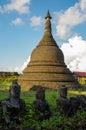 An ancient pagoda of the Mrauk U, Myanmar heritage in the back of small, damaged Buddha statues