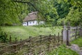 Ancient peasant Ukrainian house in the spring with a thatched roof in the old village of national architecture Royalty Free Stock Photo