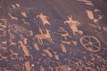 Ancient petroglyphs carved into a sandstone wall in the desert.