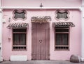 Ancient, pink building with a wooden door