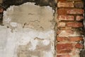 The ancient cement walls constructed of red bricks are cracked, patterned, mottled and dirty over time